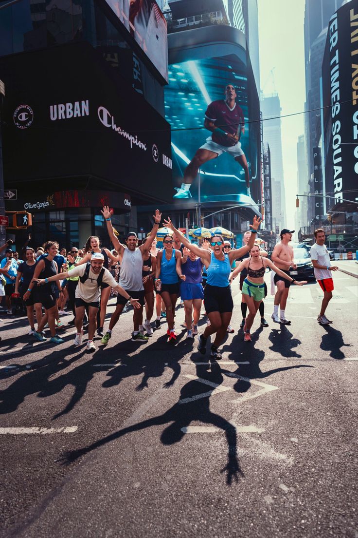 A running crew cheering together with arms in the air