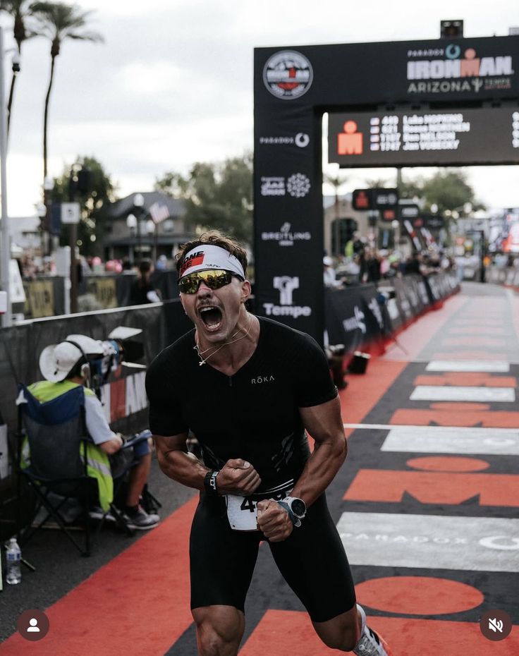 Triathlete roaring as he crosses an Ironman finish line